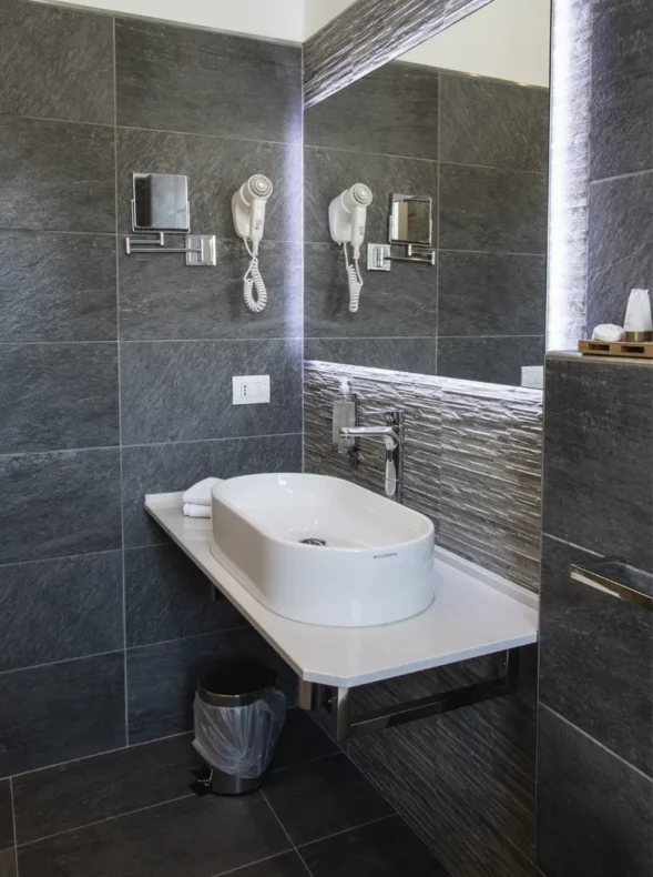 Bagno della camera con lavabo, specchio e phon